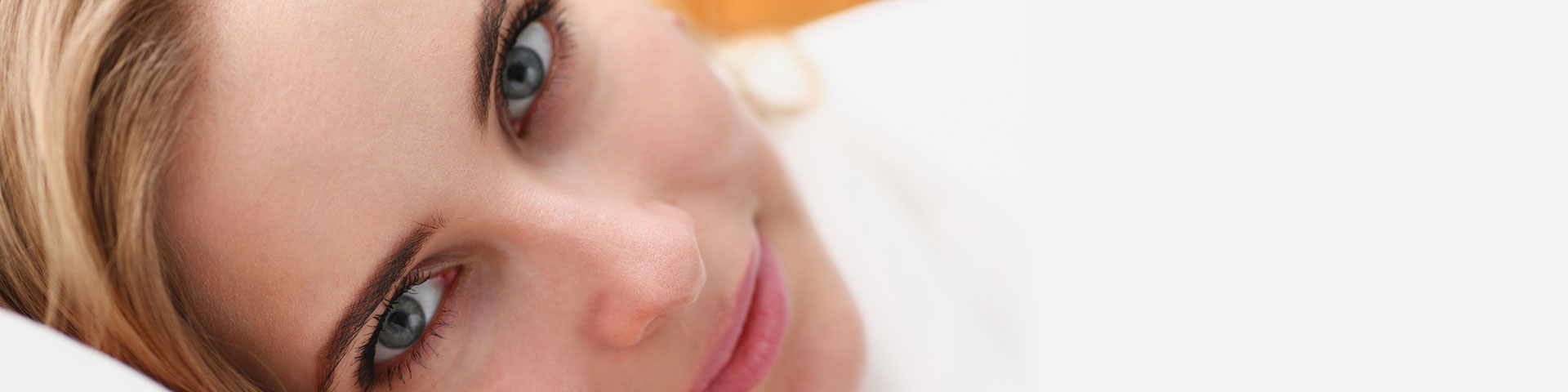 Gesicht einer jungen Frau mit blaugrauen Augen